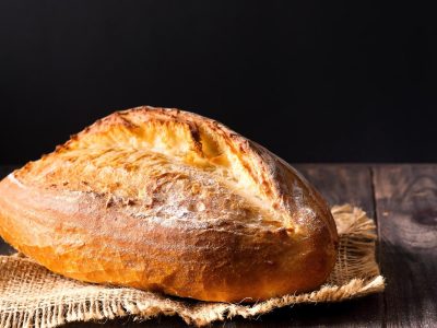 Rustic bread roll or french baguette, wheat and flour on wooden. Rural kitchen or bakery -